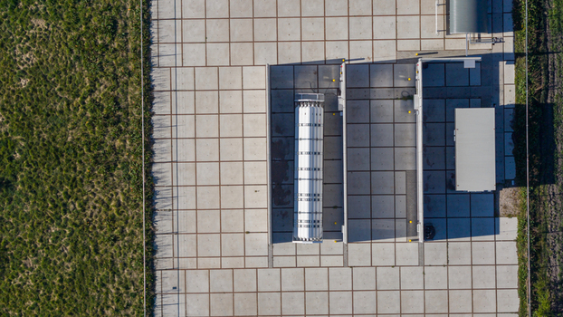 Aerial view of the Erflanden industrial facility featuring a large white storage tank on a concrete tiled platform with utility buildings in Hoogeveen Drenthe Netherlands.