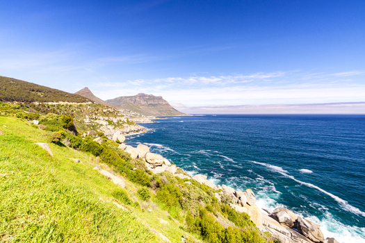 View of the rugged coastline and mountains overlooking the blue ocean under a clear sky in Cape Town Western Cape South Africa. View of the rugged coastline and mountains overlooking the blue ocean under a clear sky in Cape Town Western Cape South Africa.