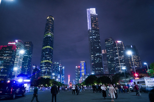 Guangzhou Guangdong Province China 23 February 2024 View of illuminated skyscrapers and modern architecture in the Zhujiang New Town business district at night with people walking. Guangzhou Guangdong Province China 23 February 2024 View of illuminated skyscrapers and modern architecture in the Zhujiang New Town business district at night with people walking.