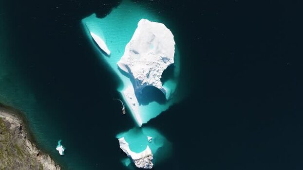 Aerial view of iceberg and boat in Greenland. Aerial view of iceberg and boat in Greenland.