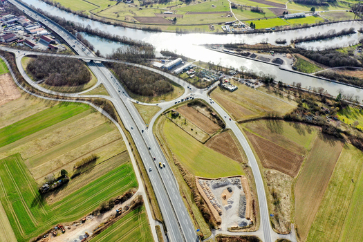 Aerial view of a highway interchange with cars driving through green fields and near a river in Forchheim Bavaria Germany. Aerial view of a highway interchange with cars driving through green fields and near a river in Forchheim Bavaria Germany.