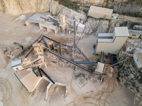 Aerial view of the industrial stone quarry in Teulada featuring conveyor belts processing machinery and rock extraction areas in Teulada Valencian Community Spain.
