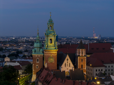 Aerial view of Wawel Royal Castle with its illuminated towers and red rooftops at twilight in Krakow Lesser Poland Voivode Poland. Aerial view of Wawel Royal Castle with its illuminated towers and red rooftops at twilight in Krakow Lesser Poland Voivode Poland.