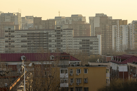 View of dense residential apartment blocks and high rise buildings under a hazy golden sunset sky Beijing Beijing China. View of dense residential apartment blocks and high rise buildings under a hazy golden sunset sky Beijing Beijing China.