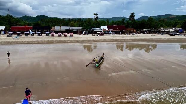 Aerial view of a beach with a traditional boat in Bali Indonesia.
