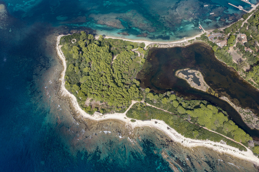 Aerial view of Ile Sainte Marguerite featuring dense pine forests rocky coastlines and clear turquoise waters near the shore in Cannes Provence Alpes Cote d Azur France. Aerial view of Ile Sainte Marguerite featuring dense pine forests rocky coastlines and clear turquoise waters near the shore in Cannes Provence Alpes Cote d Azur France.