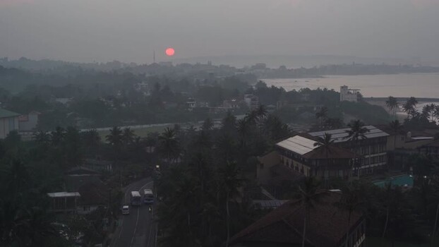 View of a red sunset over a misty coastal town Sri Lanka. View of a red sunset over a misty coastal town Sri Lanka.