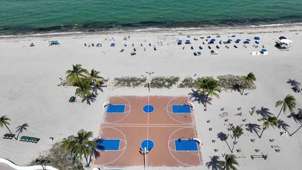 Aerial view of the basketball court on the sandy beach with turquoise waters meeting the shore Miami Beach Florida United States.