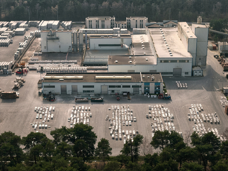 Aerial view of an industrial facility with large warehouses storage yards filled with palletized goods and surrounding forest in Dulmen North Rhine Westphalia Germany. Aerial view of an industrial facility with large warehouses storage yards filled with palletized goods and surrounding forest in Dulmen North Rhine Westphalia Germany.