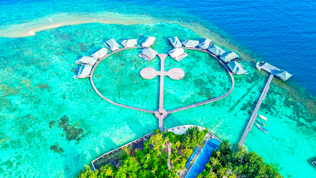 Aerial view of Grand Mega Diving Resort with circular overwater bungalows over turquoise reefs connected by wooden walkways Karimunjawa Central Java Indonesia.