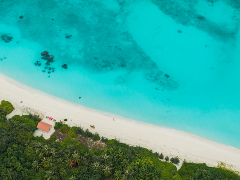 Aerial view of turquoise waters meet the pristine white beach fringed by lush greenery Vashafaru Island Thiladhummathi Atoll Maldives. Aerial view of turquoise waters meet the pristine white beach fringed by lush greenery Vashafaru Island Thiladhummathi Atoll Maldives.