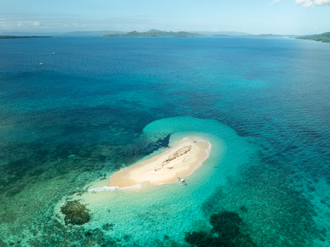Aerial view of Naked Island a small sandbar surrounded by turquoise coral reefs and deep blue ocean waters in Siargao Philippines. Aerial view of Naked Island a small sandbar surrounded by turquoise coral reefs and deep blue ocean waters in Siargao Philippines.
