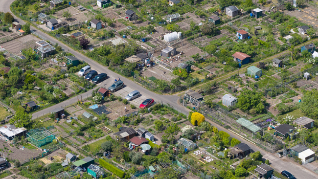 Aerial view of Amateur Gardeners Association Het Kloosterpark with its numerous allotment plots small sheds and greenhouses under bright sunlight De Bilt Utrecht Netherlands.