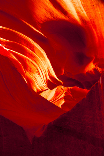 View of the smooth flowing sandstone walls of Antelope Canyon with vibrant orange and red light patterns reflecting off the rock surfaces in Coconino County Arizona United States. View of the smooth flowing sandstone walls of Antelope Canyon with vibrant orange and red light patterns reflecting off the rock surfaces in Coconino County Arizona United States.