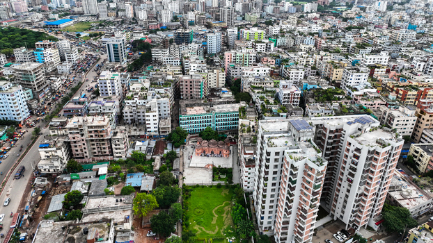 Aerial view of the dense urban landscape of Dhaka featuring a historic mosque surrounded by modern residential buildings rooftops and bustling streets in Dhaka Dhaka Division Bangladesh. Aerial view of the dense urban landscape of Dhaka featuring a historic mosque surrounded by modern residential buildings rooftops and bustling streets in Dhaka Dhaka Division Bangladesh.