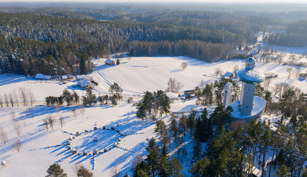 Aerial view of the Lithuanian Museum of Ethnocosmology with its futuristic observatory tower and glass dome amidst a snowy winter forest in Kulionys Utenos apskritis Lithuania.