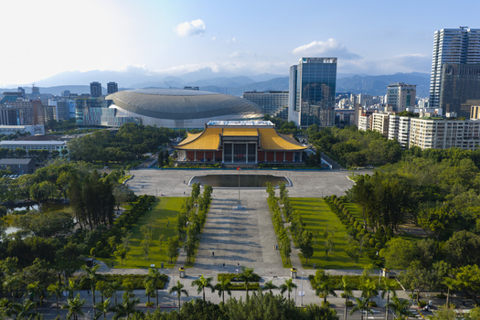 Aerial view of Sun Yat sen Memorial Hall with its iconic yellow roof surrounded by lush parkland and the modern Taipei Dome set against the urban skyline of Taipei Taiwan. Aerial view of Sun Yat sen Memorial Hall with its iconic yellow roof surrounded by lush parkland and the modern Taipei Dome set against the urban skyline of Taipei Taiwan.