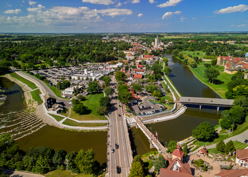 Aerial view of the town of Frankenmuth featuring the historic covered bridge over the Cass River surrounded by lush trees and buildings in Frankenmuth Michigan United States.