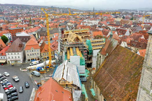 Aerial view of Rathaus Forchheim under renovation with scaffolding and yellow construction cranes surrounded by historic red tiled rooftops Forchheim Bayern Germany. Aerial view of Rathaus Forchheim under renovation with scaffolding and yellow construction cranes surrounded by historic red tiled rooftops Forchheim Bayern Germany.