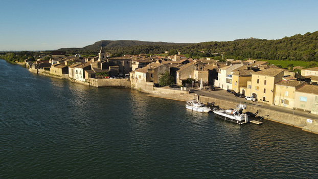 Aerial view of the historic village of Saint Etienne des Sorts featuring stone houses a church tower and boats along the riverbank in Saint Etienne des Sorts Occitanie France. Aerial view of the historic village of Saint Etienne des Sorts featuring stone houses a church tower and boats along the riverbank in Saint Etienne des Sorts Occitanie France.