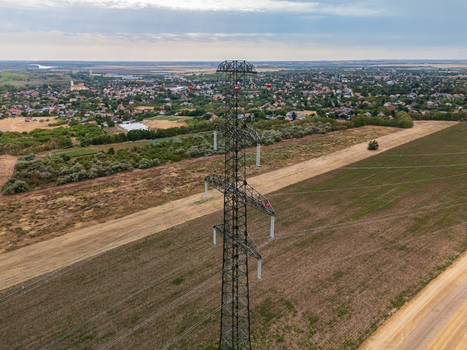 Aerial view of power lines and towers crossing farmland in Hungary in summer Aerial view of power lines and towers crossing farmland in Hungary in summer