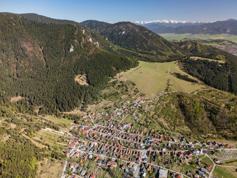 Aerial view of the village of Valaska Dubova nestled at the foot of lush green mountains with dense forests and distant peaks in Valaska Dubova Zilina Region Slovakia. Aerial view of the village of Valaska Dubova nestled at the foot of lush green mountains with dense forests and distant peaks in Valaska Dubova Zilina Region Slovakia.