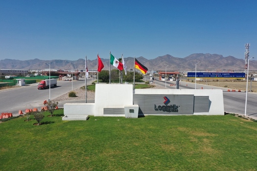 San Luis Potosi Mexico 24 February 2026 Aerial view of the Parque Industrial Logistik entrance with flags office sign truck on the road and mountains under a clear blue sky. San Luis Potosi Mexico 24 February 2026 Aerial view of the Parque Industrial Logistik entrance with flags office sign truck on the road and mountains under a clear blue sky.