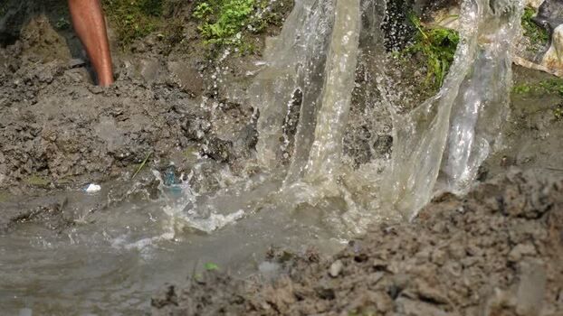 View of water splashing into a muddy field in Bogura Bangladesh. View of water splashing into a muddy field in Bogura Bangladesh.