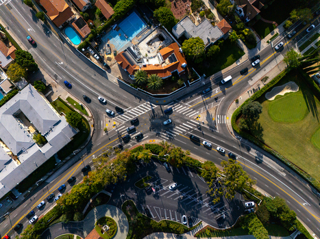 Aerial view of Wilshire Country Club intersection with surrounding streets lush green golf course fairways and traffic flowing through the crossing in Los Angeles California United States. Aerial view of Wilshire Country Club intersection with surrounding streets lush green golf course fairways and traffic flowing through the crossing in Los Angeles California United States.