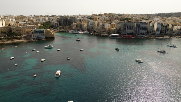 Aerial view of the turquoise waters of Balluta Bay filled with small boats and yachts bordered by the urban architecture of St. Julian s in Malta. Aerial view of the turquoise waters of Balluta Bay filled with small boats and yachts bordered by the urban architecture of St. Julian s in Malta.
