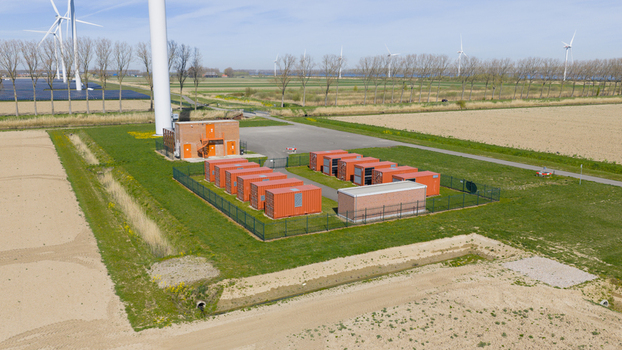 Aerial view of battery storage system at wind park with wind turbines