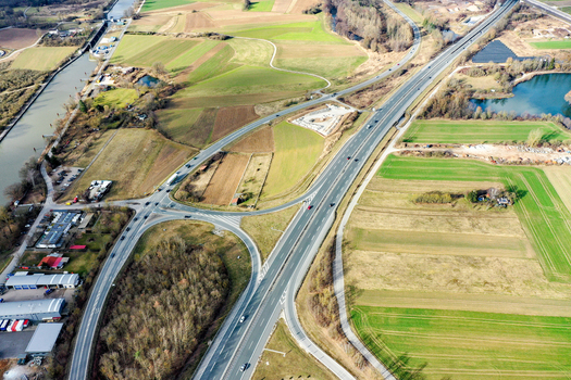 Aerial view of a highway interchange crossing through agricultural fields and a canal under bright daylight in Forchheim Bavaria Germany. Aerial view of a highway interchange crossing through agricultural fields and a canal under bright daylight in Forchheim Bavaria Germany.