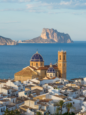 Aerial view of the Church of Our Lady of Consolation with iconic blue tiled domes rising above white washed houses overlooking the Mediterranean Sea in Altea Valencian Community Spain.