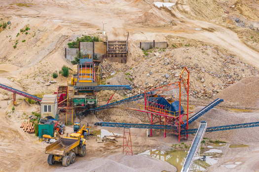 Aerial view of a gravel pit with heavy machinery conveyor belts and piles of sand and gravel in Tczew Pomeranian Voivodeship Poland. Aerial view of a gravel pit with heavy machinery conveyor belts and piles of sand and gravel in Tczew Pomeranian Voivodeship Poland.