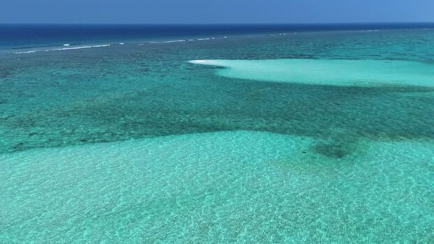 Aerial view of turquoise coral reefs and clear ocean water in Maldives. Aerial view of turquoise coral reefs and clear ocean water in Maldives.