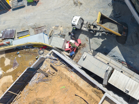 Aerial view of a construction site featuring a dump truck unloading gravel temporary site offices and various building materials in Istanbul Istanbul Turkey. Aerial view of a construction site featuring a dump truck unloading gravel temporary site offices and various building materials in Istanbul Istanbul Turkey.