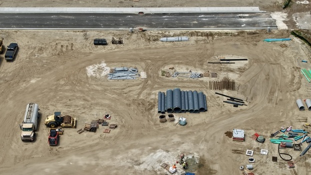 Aerial view of the construction site at Foundry Lane featuring heavy machinery large drainage pipes and building materials on a dirt lot World Golf Village Florida United States.
