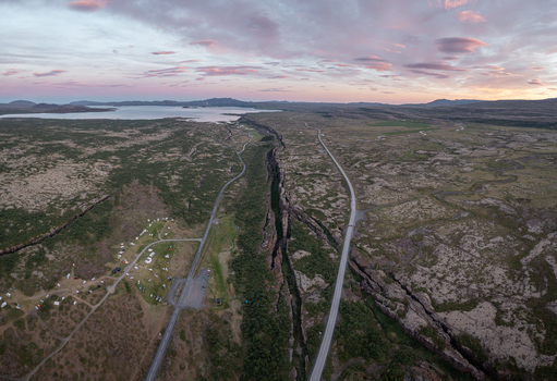 Aerial view of Thingvellir National Park showing the dramatic tectonic rift winding roads a campsite and the vast lake under a sunset sky in Selfoss Blaskogabyggd Iceland. Aerial view of Thingvellir National Park showing the dramatic tectonic rift winding roads a campsite and the vast lake under a sunset sky in Selfoss Blaskogabyggd Iceland.