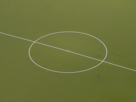 Aerial view of a soccer field center circle with white markings on green artificial turf in Berlin Berlin Germany. Aerial view of a soccer field center circle with white markings on green artificial turf in Berlin Berlin Germany.