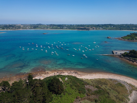 Aerial view of Plage de Port Blanc with numerous small boats anchored in turquoise waters along the rugged coastline of Penvenan Bretagne France. Aerial view of Plage de Port Blanc with numerous small boats anchored in turquoise waters along the rugged coastline of Penvenan Bretagne France.