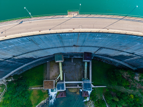 Aerial view of Barrage de Rossens showing the curved concrete wall road on top and water outlet structures in Pont la Ville Fribourg Switzerland.