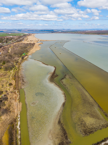 Aerial view of Lake Atanasovsko showing the shallow salt pans and coastal lagoon landscape under a blue sky with scattered clouds in Burgas Burgas Bulgaria. Aerial view of Lake Atanasovsko showing the shallow salt pans and coastal lagoon landscape under a blue sky with scattered clouds in Burgas Burgas Bulgaria.