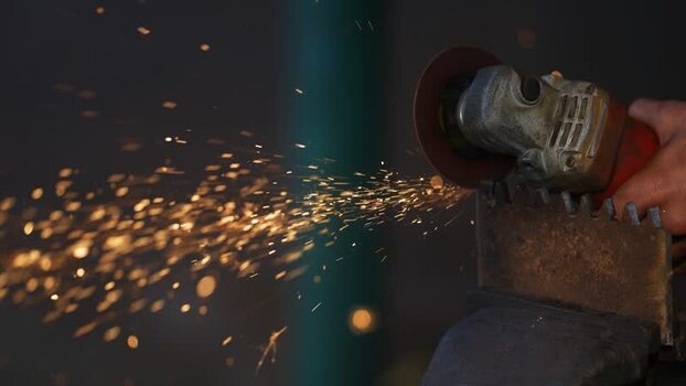 View of a worker using an angle grinder with sparks Bangladesh.