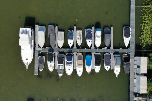 Aerial view of motorboats and yachts docked at the Aschaffenburger Bootsclub pier on the green water of the Main river in Aschaffenburg Bayern Germany.