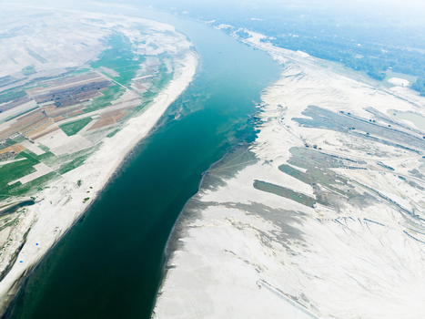 Aerial view of the Jamuna River flowing through the sandy landscape and agricultural fields along the riverbanks in Tangail Dhaka Division Bangladesh. Aerial view of the Jamuna River flowing through the sandy landscape and agricultural fields along the riverbanks in Tangail Dhaka Division Bangladesh.
