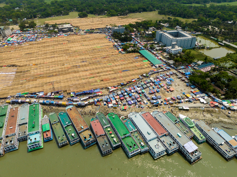 Aerial view of boats lined up along the shore near the Baitul Mukarram Mosque amidst bustling markets and verdant landscapes Charmonai Barisal Division Bangladesh. Aerial view of boats lined up along the shore near the Baitul Mukarram Mosque amidst bustling markets and verdant landscapes Charmonai Barisal Division Bangladesh.