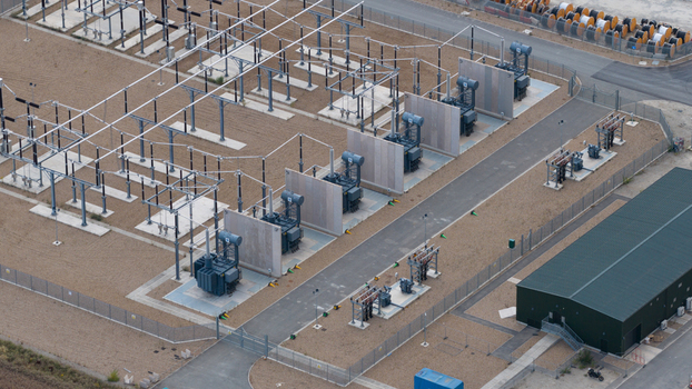 Aerial view of an electrical substation featuring large transformers metal power structures and gravel grounds in London England United Kingdom.