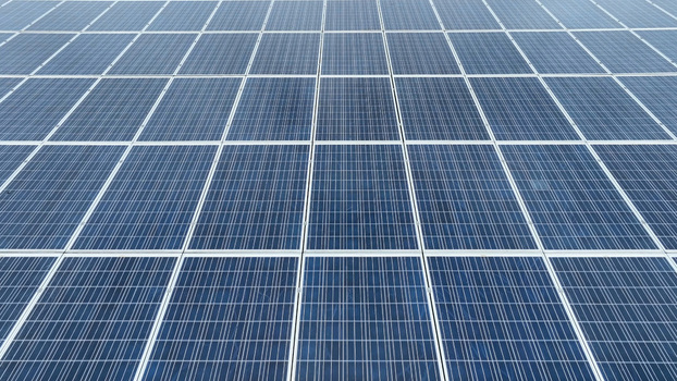 Aerial view of a large array of blue photovoltaic solar panels arranged in a geometric grid pattern in Neffsville Pennsylvania United States.