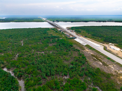Aerial view of the bridge and road infrastructure crossing the river at Bonny Island surrounded by dense mangrove forests in Bonny Rivers Nigeria.