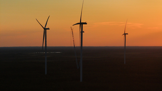 Aerial view of Metsalamminkangas wind farm with wind turbines silhouetted against a vibrant sunset sky in Siikalatva Pohjois Pohjanmaa Finland. Aerial view of Metsalamminkangas wind farm with wind turbines silhouetted against a vibrant sunset sky in Siikalatva Pohjois Pohjanmaa Finland.